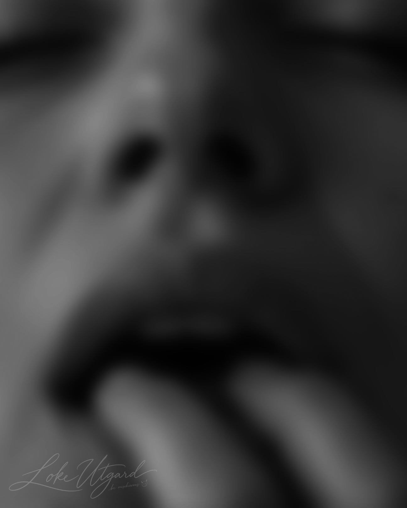 Blurred monochrome portrait of a woman with her fingers near her mouth.