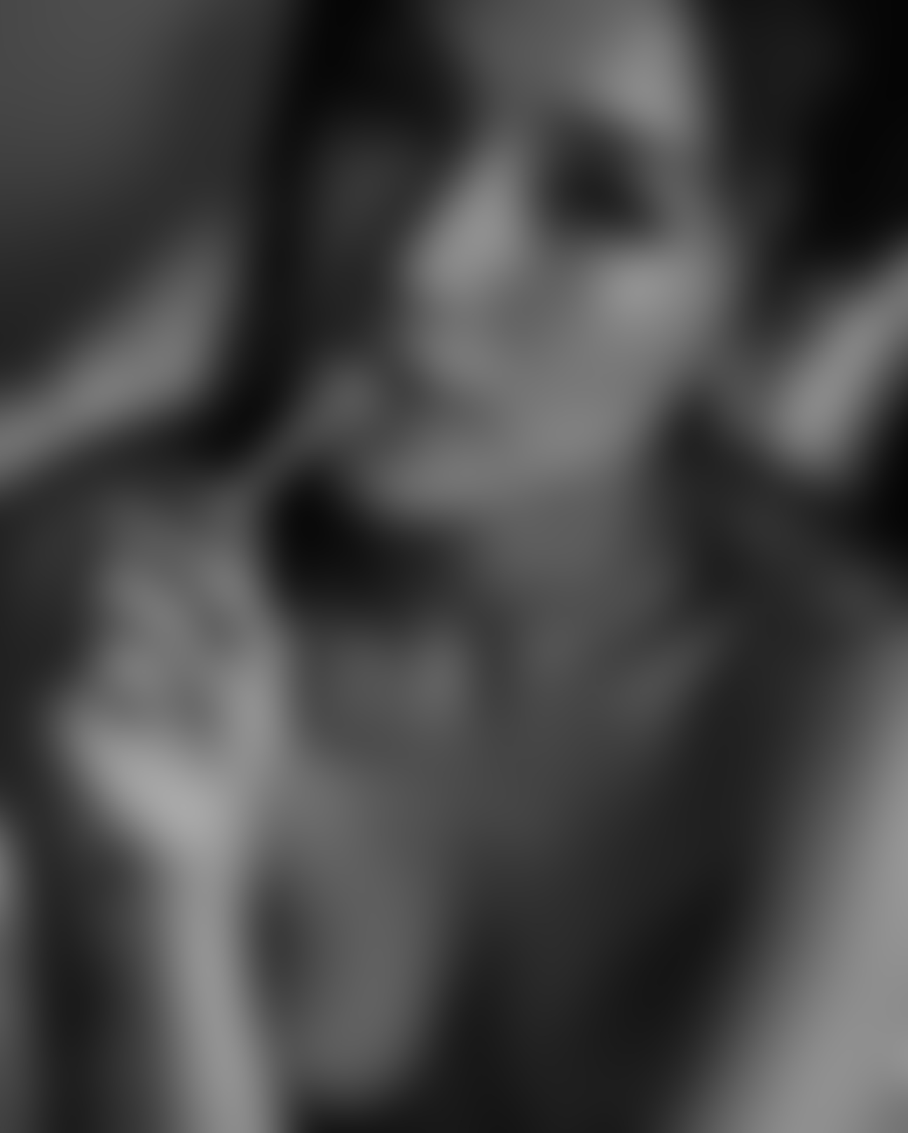 Heavily blurred monochrome portrait with a hand near the face.