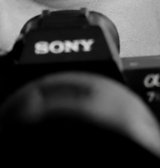 Black-and-white close-up of a Sony camera and lens