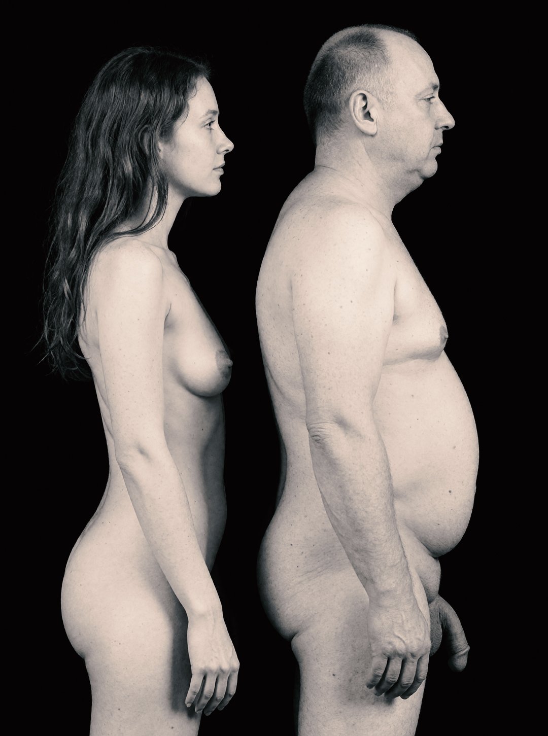 Monochrome side-profile nude portrait of Gabby and M against a black background