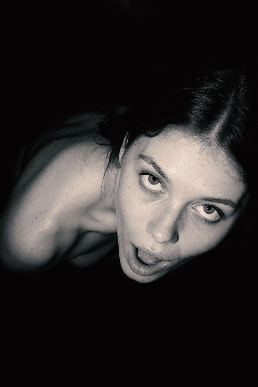 High-angle monochrome close portrait of Lisel against a dark background