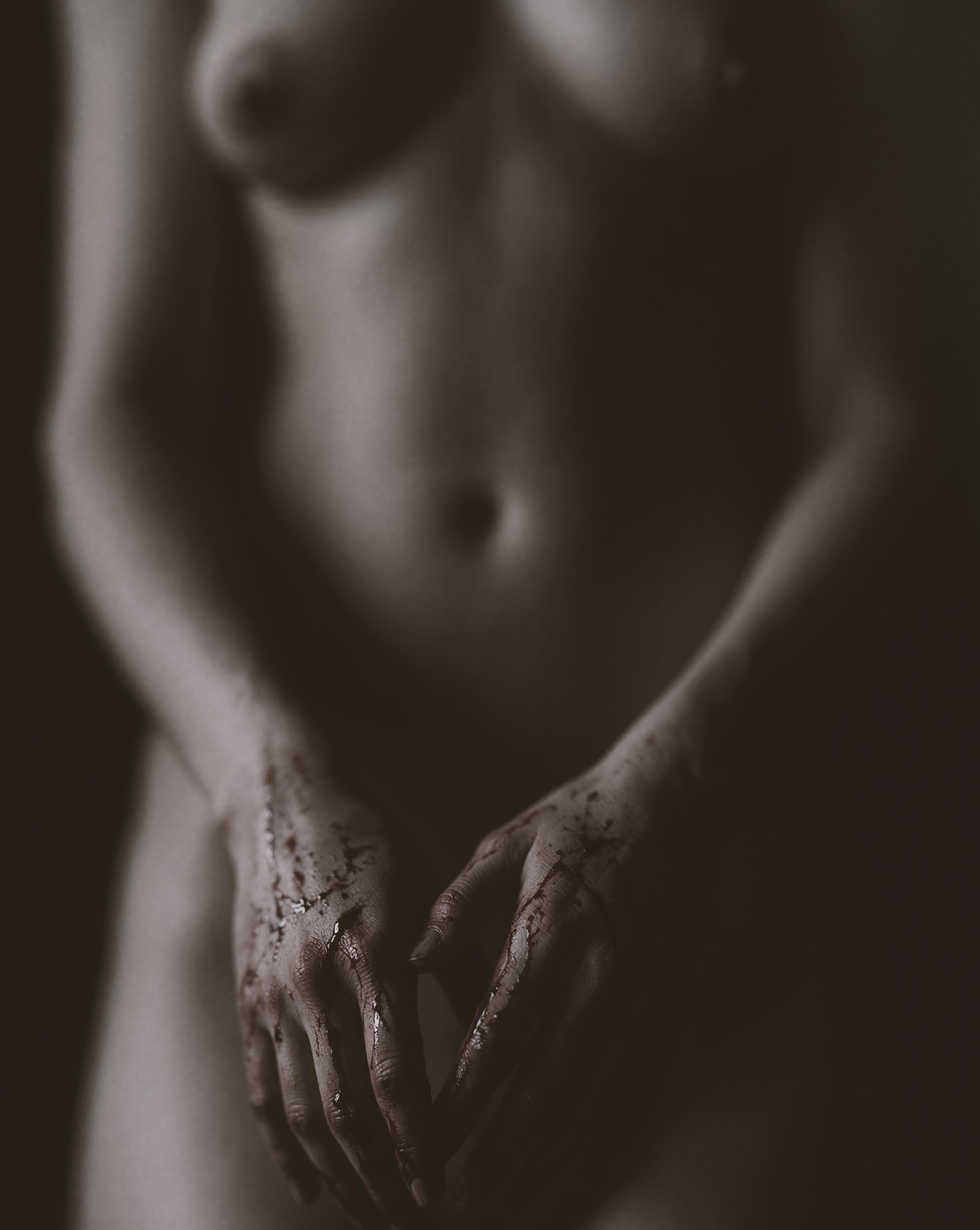 Soft-focus low-key portrait of Mette with red-stained hands