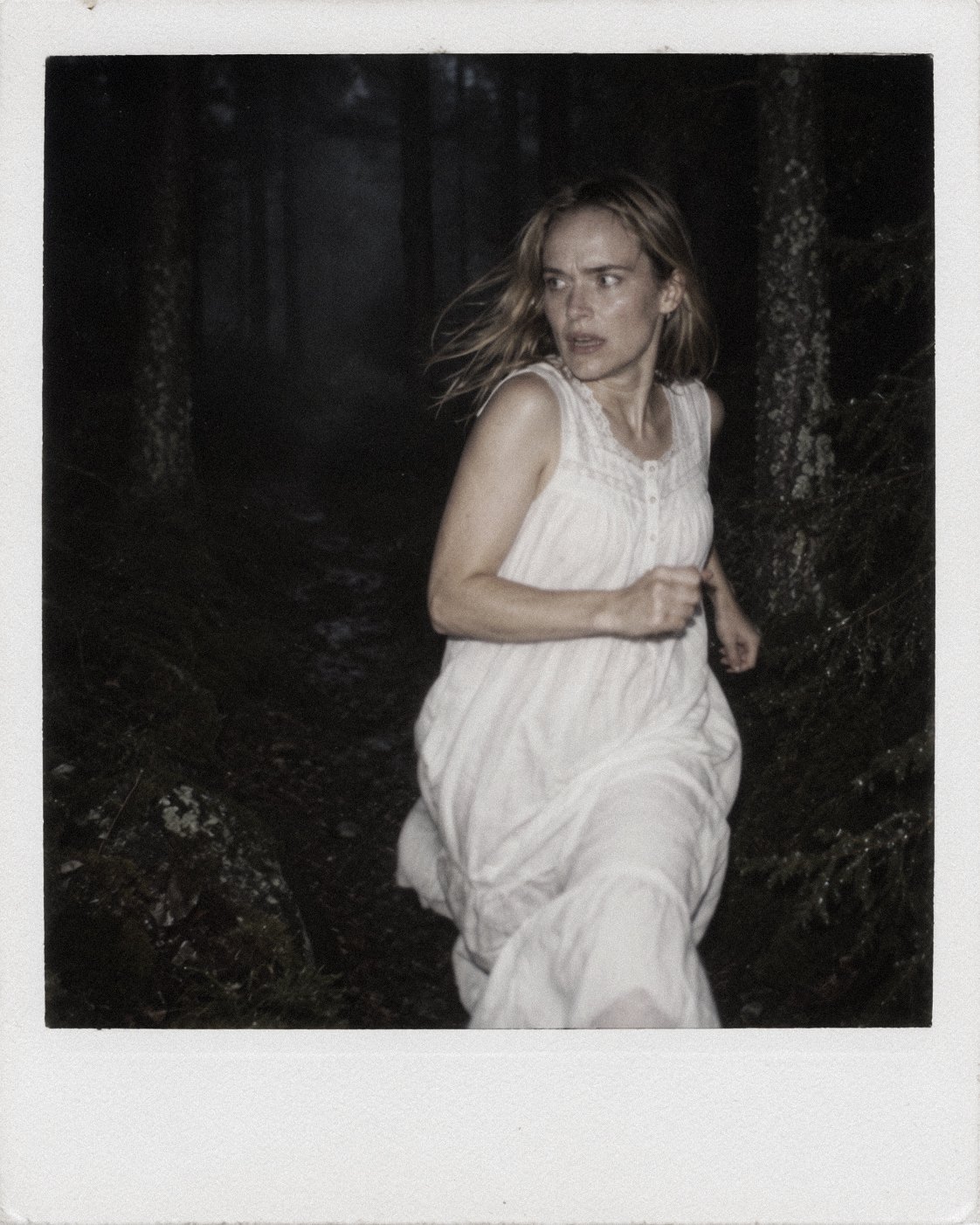 Nightmare series portrait of a woman running through a dark forest