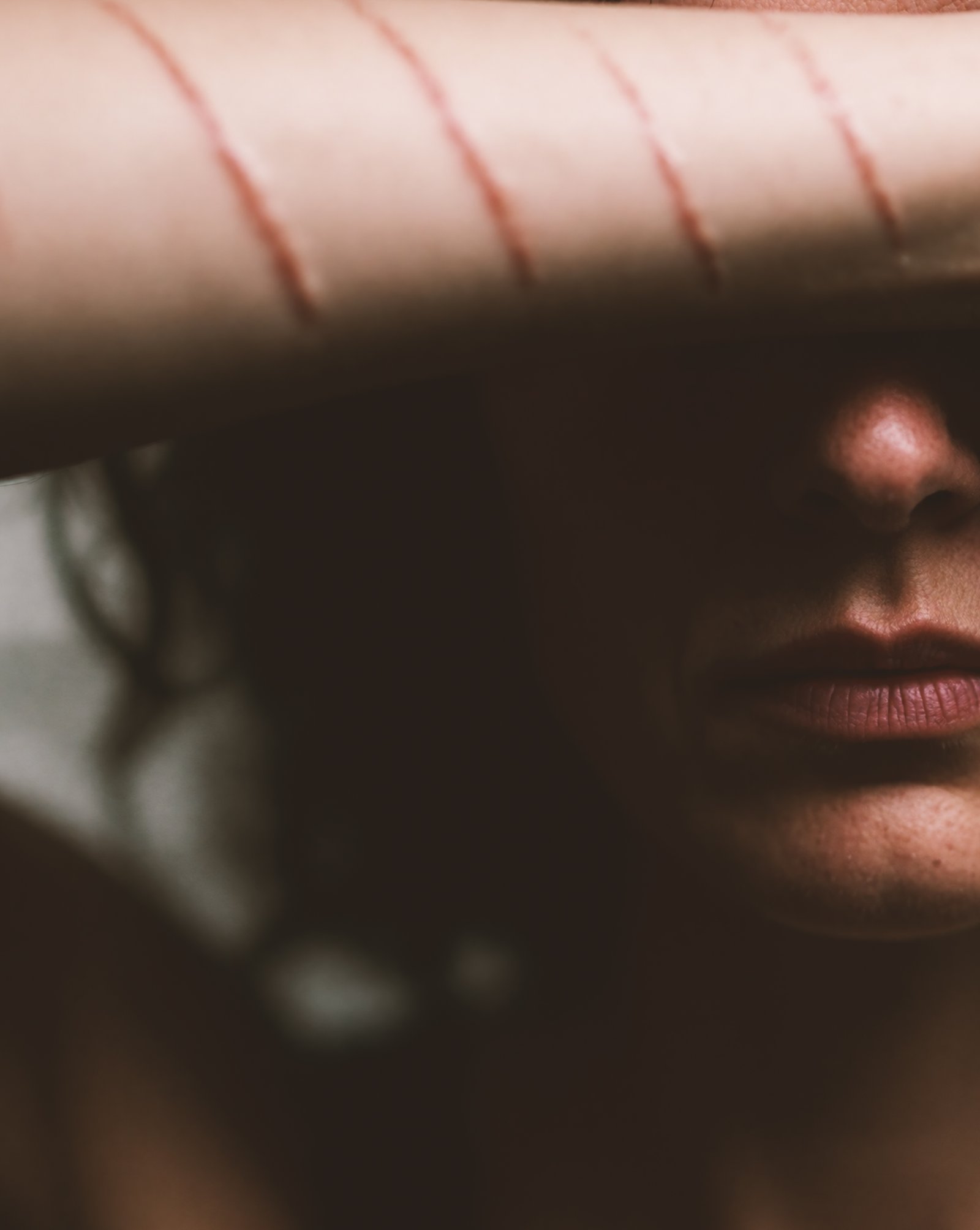 Close portrait of Silje with her forearm casting a shadow across her face